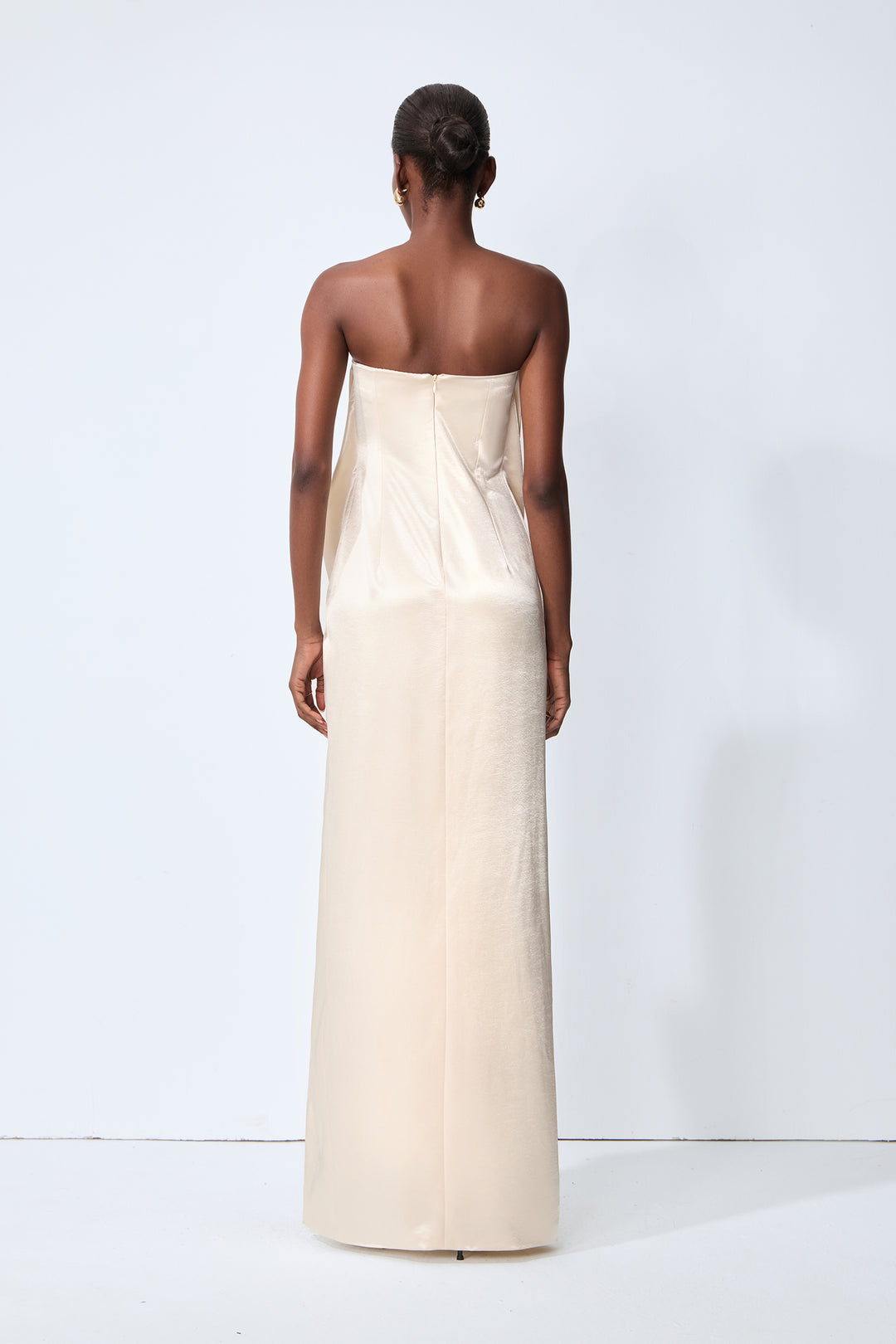 Model trägt Champagner-Beiges Maxi-Satin-Kleid bei einer Abendveranstaltung - KYMA