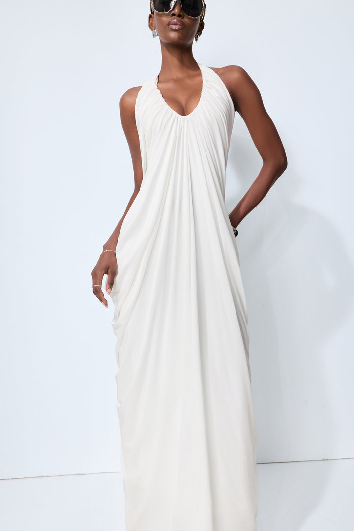 Model trägt das weiße Maxikleid mit Drapierung - KYMA