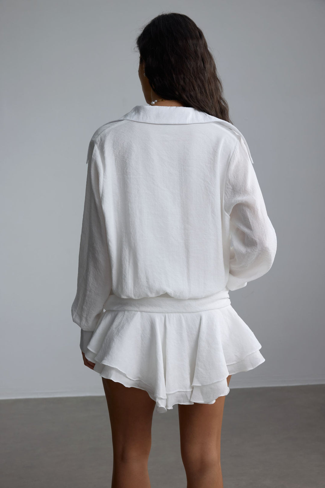 Felicia Chiffon Mini Shirt Dress White, zeigt das plissierte Design und die Vordertaschen – KYMA