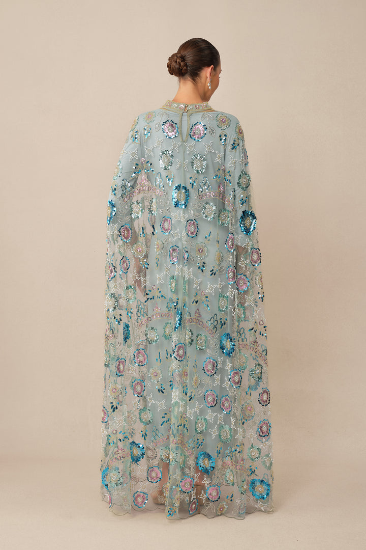 Model trägt das blaue Pailletten-Cape-Kleid - KYMA