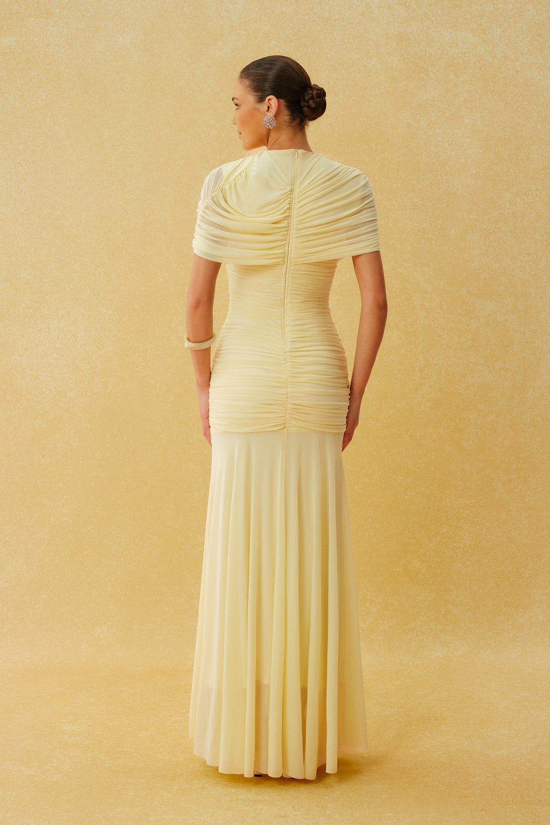 Model trägt das gelbe Maxikleid in einer eleganten Pose