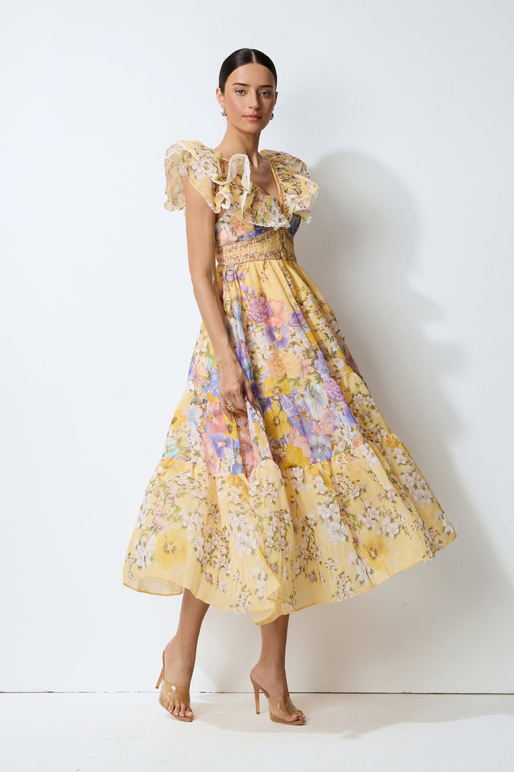 Model trägt das gelbe geblümte Midikleid