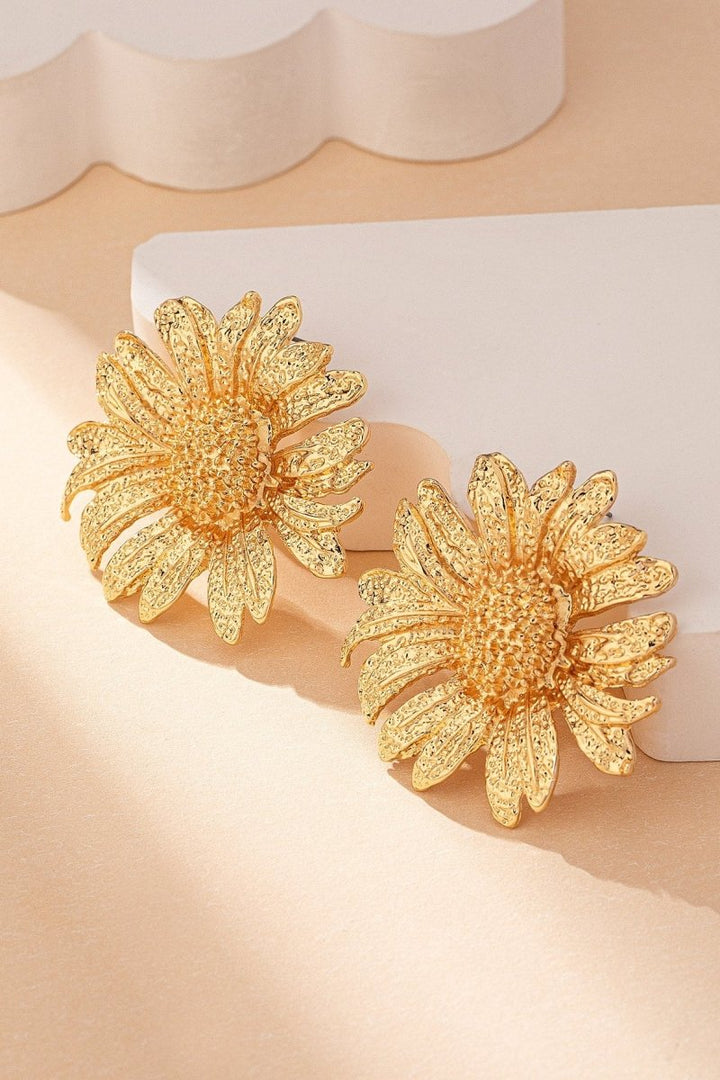 Naheinstellung eines goldenen Ohrrings mit Sonnenblumen-Anhänger